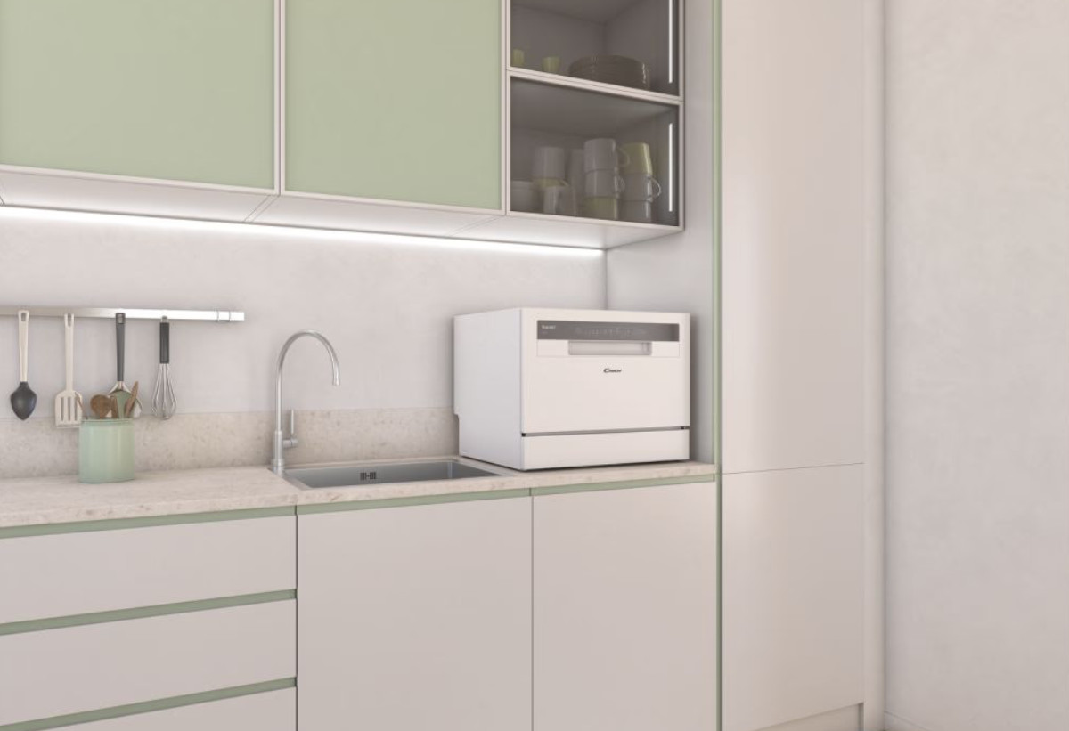  Στην εικόνα απεικονίζεται το πλυντήριο πιάτων τοποθετημένο στον πάγκο μιας κουζίνας με ανοιχτή πόρτα και γεμάτο με σκεύη.